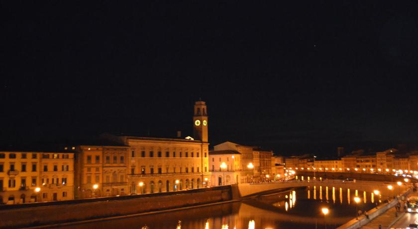 a city street at night with a large clock tower, You & Me in Pisa