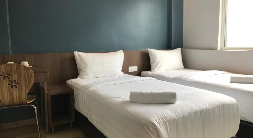 a white bed sitting in a room next to a window, Festival Boutique Hotel - Damai Complex in Kuala Lumpur