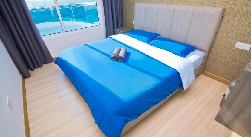 a bed that has a blue blanket on top of it, Cardamom The Wave&Atlantis Residence Melaka Town in Malacca