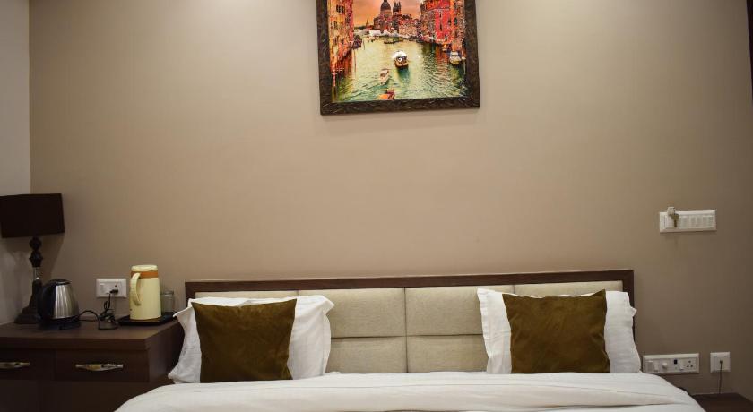 a bedroom with a bed and a painting on the wall, Hotel Singh Comfort Inn in Gorakhpur