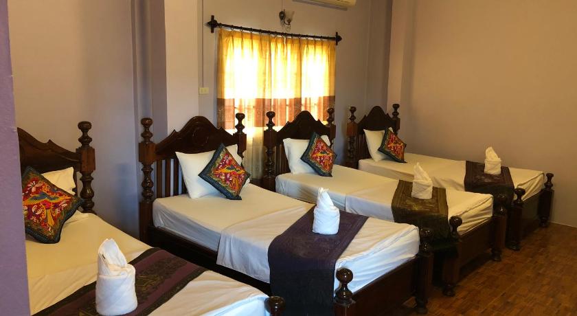 a hotel room with two beds and two tables, Sout Jai Guest House & Restaurant in Vang Vieng