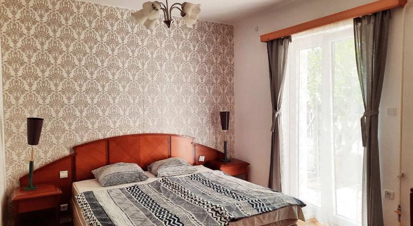 a bedroom with a bed and a window, Szarszo Szallo in Balatonlelle