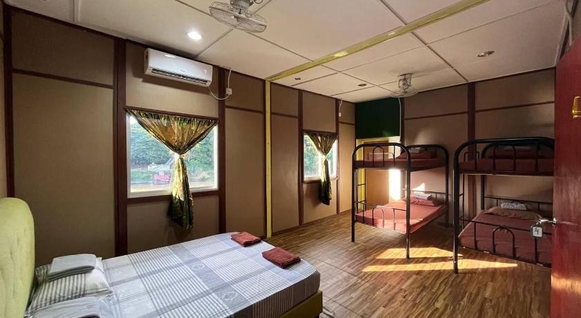 a bedroom with a bed and a desk, Liana Hostel Taman Negara in Kuala Tahan