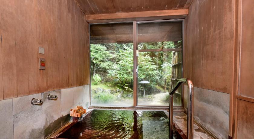 a bathroom with a tub and a sink in it, Sanyoso in Izu