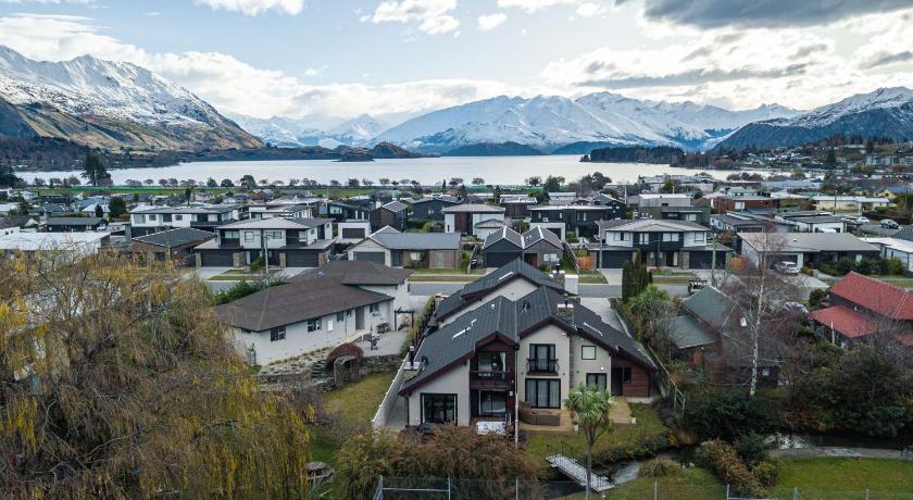 a small town with houses and a mountain range, Tranquil Stream Side Retreat in Wanaka