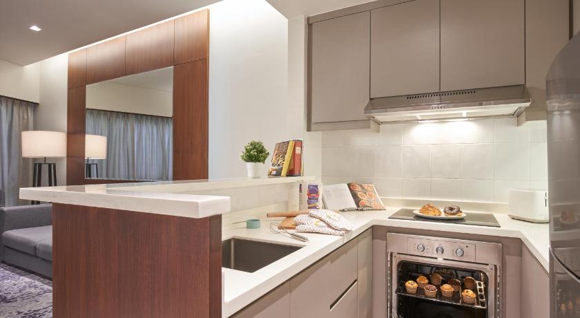 a kitchen with a stove top oven and a microwave, Somerset Bencoolen Singapore (SG Clean Certified) in Singapore