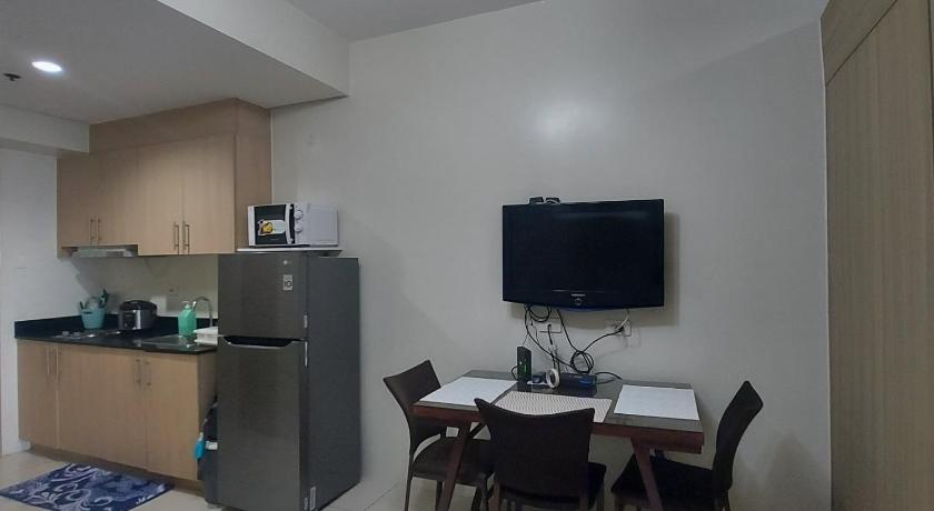 a kitchen with a table and chairs and a refrigerator, Suite 3049 in Manila