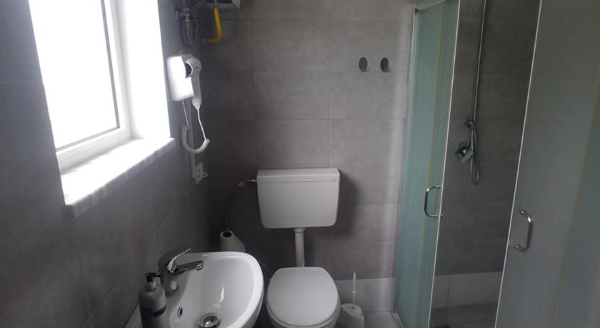 a bathroom with a sink, toilet and bathtub, Green Garden Guesthouse in Shkoder