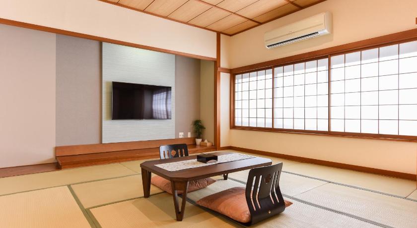 a room with a table, chairs and a window, Ikaho Onsen Kokuya in Shibukawa