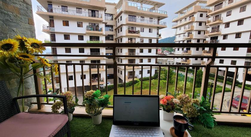 a laptop computer sitting on top of a wooden table, DOT ACCREDITED 1209 CONDO UNIT Bristle Ridge Condo Cozy 2 Bedroom in Baguio