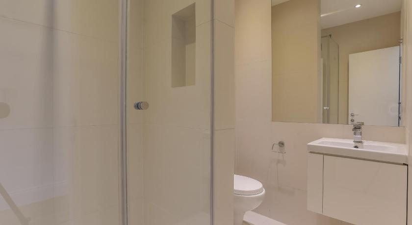 a white toilet sitting next to a bath tub, Kings Cross Serviced Apartments in London