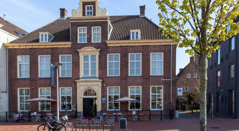 a large building with a clock on the front of it, Best Western Museumhotels Delft in Delft