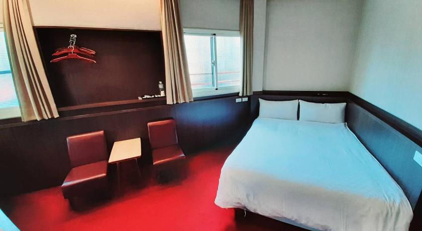 a hotel room with two beds and a television, Long Cherng Hotel in Yilan