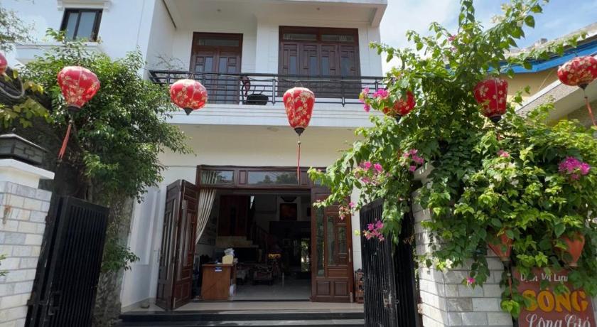 a large building with a red door and a red umbrella, Windy River Homestay in Hoi An