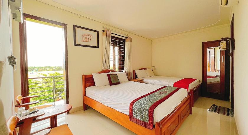 a bedroom with a large bed and a large window, Windy River Homestay in Hoi An