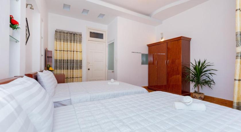 a bedroom with a large bed and a large window, Ngoc Thuan Motel in Vung Tau