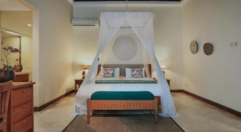 a hotel room with a bed and a canopy, Parigata Villas Resort in Bali
