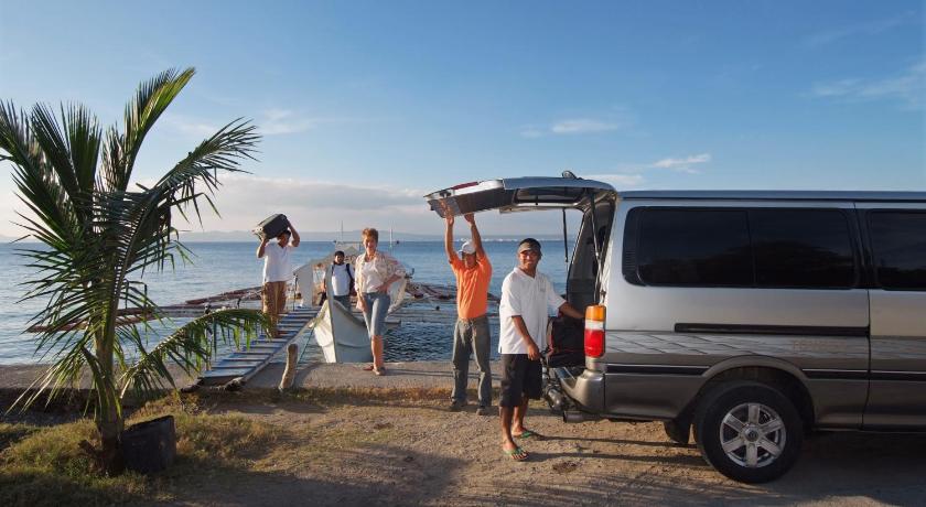 people standing on top of a beach next to a van, Atlantis Dive Resort Puerto Galera in Puerto Galera