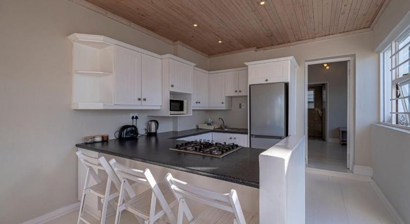 a kitchen with white cabinets and white appliances, The Bungalow in Jeffreys Bay
