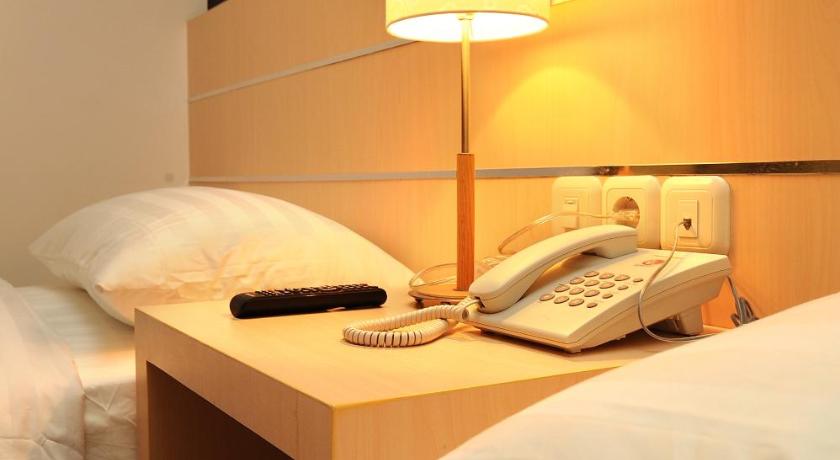 a hotel room with a bed and a lamp, Hotel Cordela Medan in Medan