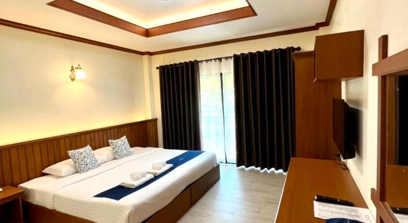 a hotel room with two beds and a television, โรงแรมเฮือนฮิมกอง in Phrae