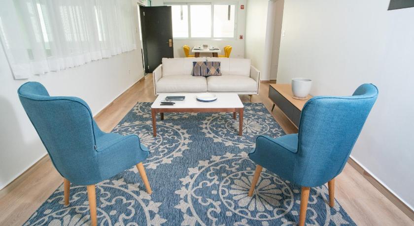 a living room filled with furniture and a blue rug, Casa Condado Hotel in San Juan