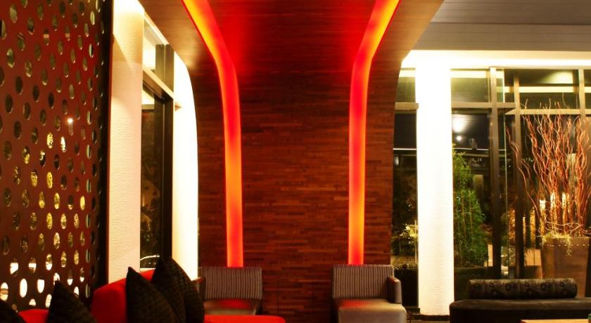 a living room filled with furniture and a red wall, Z Through By The Zign Hotel in Pattaya