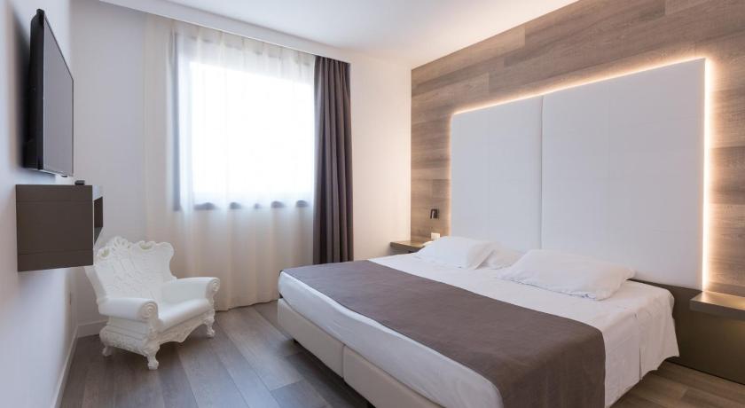 a hotel room with a white bed and white walls, City Hotel & Suites in Foligno