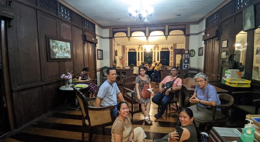 people sitting around a long wooden table, Oasis Balili Heritage Lodge in Bohol