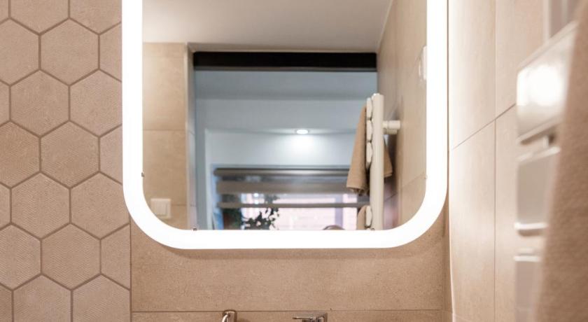 a bathroom with a sink and a mirror, Csendeskert Wellness Apartments in Balatonalmadi