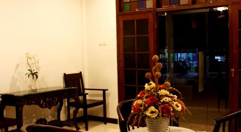 a living room filled with furniture and a table, Grand Marto Hotel in Yogyakarta