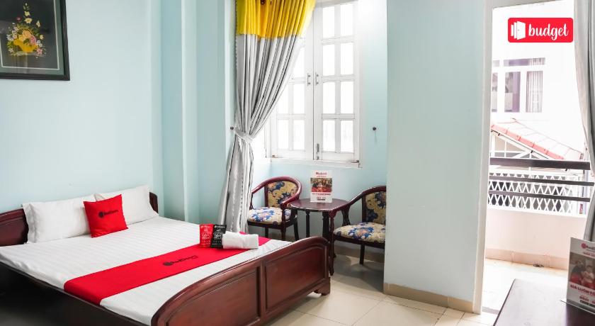 a bedroom with a bed, desk, chair and window, RedDoorz Hai Yen 2 Hotel in Ho Chi Minh City