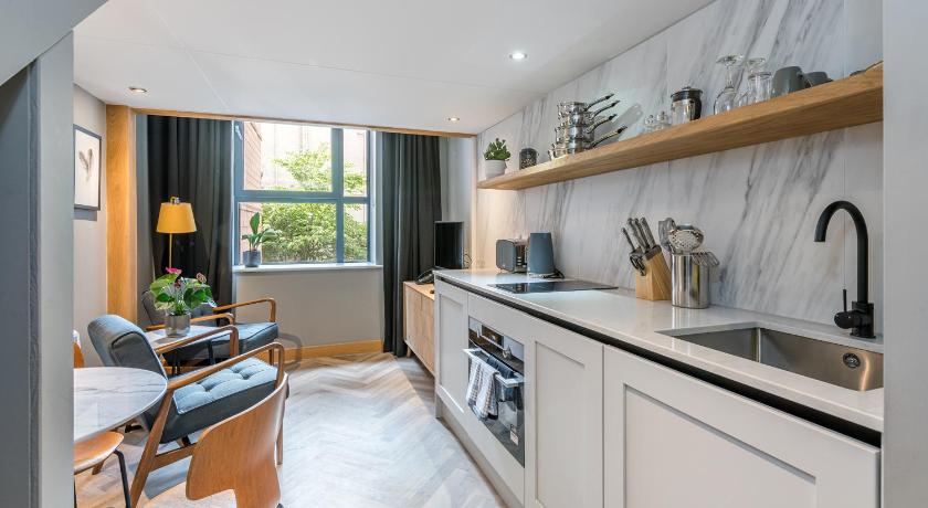 a kitchen with a stove a sink and a dishwasher, Richmond Place Apartments in Edinburgh