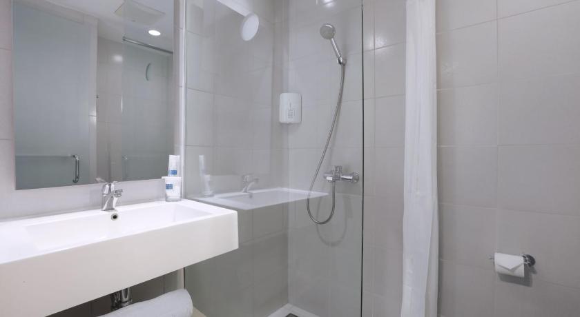 a bathroom with a shower, sink, and toilet, Hotel Algoritma by The Alts in Palembang