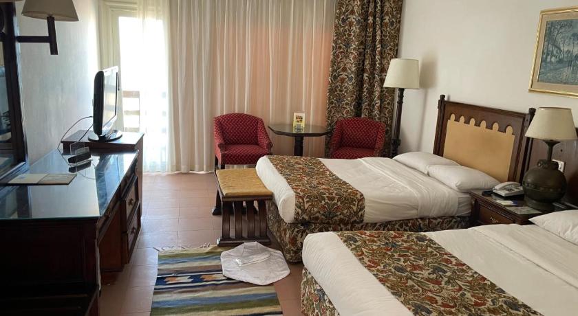a hotel room with two beds and a television, Retac El Arish in Al Arish