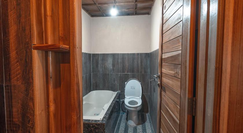 a bathroom with a toilet and a bath tub, Munduk Panorama in Bali