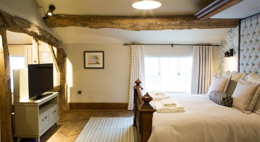 a hotel room with a bed and a television, The Legh Arms Prestbury in Prestbury
