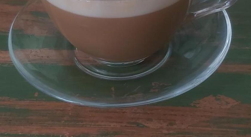 a cup of coffee sitting on top of a table, Mi Casa Guest House in Banyuwangi