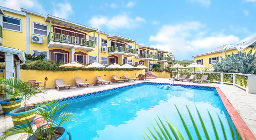 a hotel room with a pool and lawn, Grooms Beach Villa & Resort in St Georges