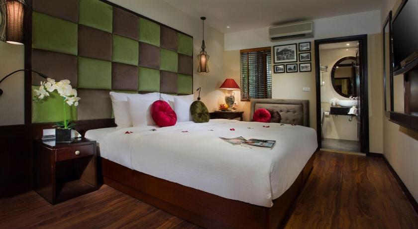a hotel room with a bed and a dresser, Ambassador Hanoi Hotel & Travel in Hanoi