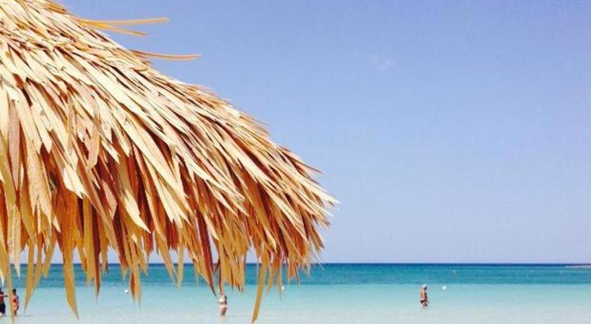 a sandy beach with a beach umbrella on top of it, Conchiglia Azzurra Resort & Beach in Porto Cesareo