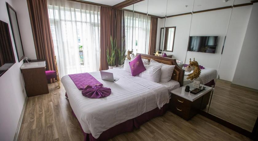a hotel room with a bed, desk, and window, Suji Hotel in Hanoi
