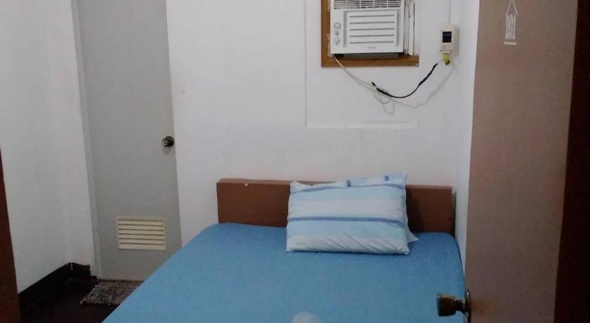 a blue and white bed sitting on top of a wooden table, Providence Travellers Inn & Spa in Bohol