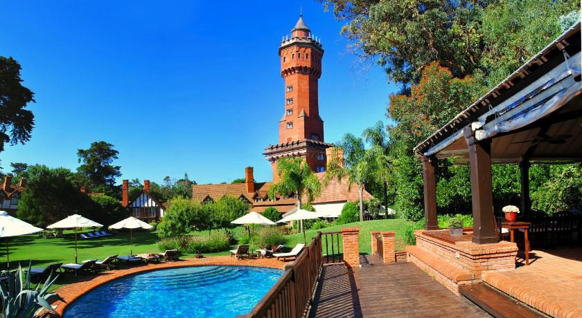 a large clock tower in front of a swimming pool, Hotel L'Auberge in Punta Del Este