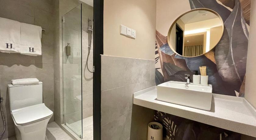 a bathroom with a toilet, sink and mirror, Harper Suite at Sutera Avenue in Kota Kinabalu