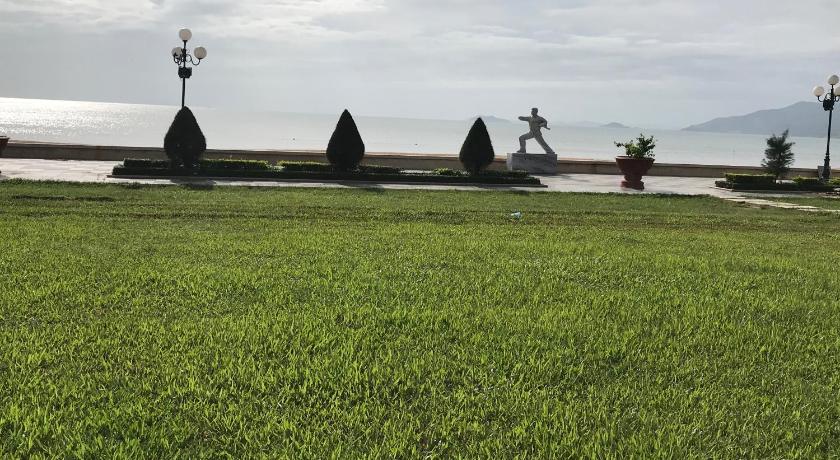 a grassy field with a couple of people standing on top of it, Hotel Hoang Hung Quy Nhon in Quy Nhơn (Bình Định)
