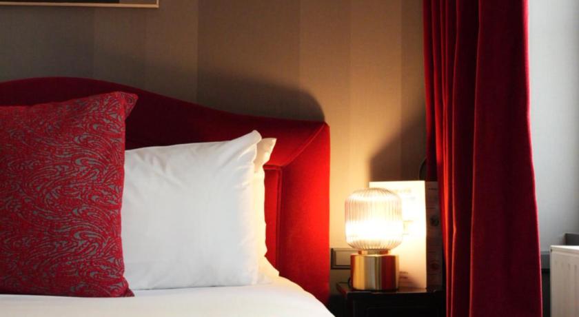 a bed room with a red bedspread and pillows, Hotel Alexandra in Lyon