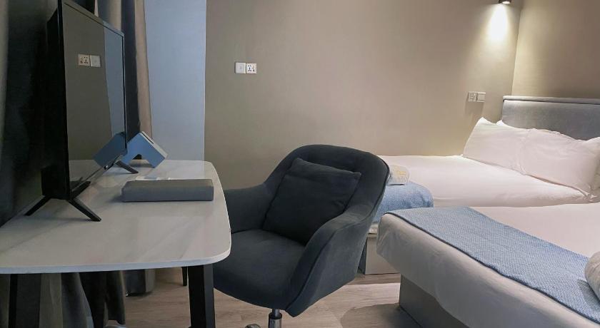 a hotel room with a bed, desk and chair, Hotel Calmo Bugis in Singapore