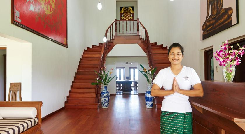 a man standing in a hallway next to a staircase, Sara Beachfront Boutique Resort in Chumphon