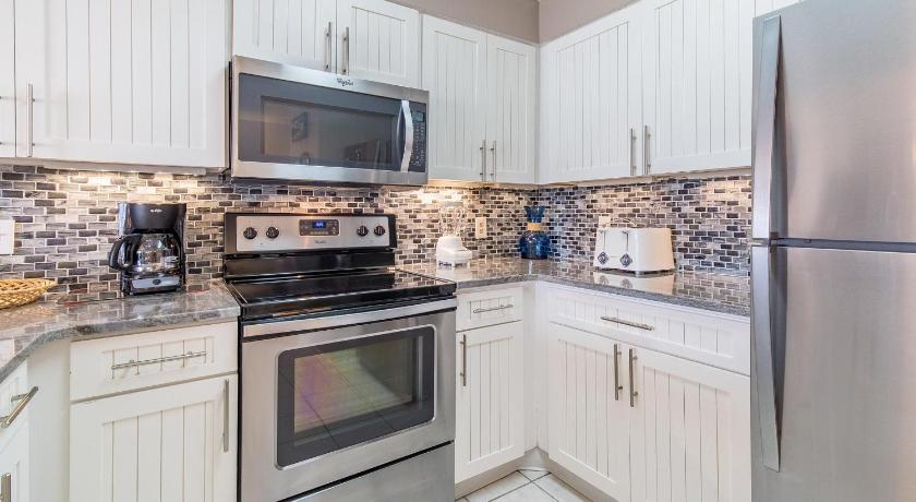 a kitchen with a stove, microwave and refrigerator, Pelican Beach Resort 410 in Destin (FL)